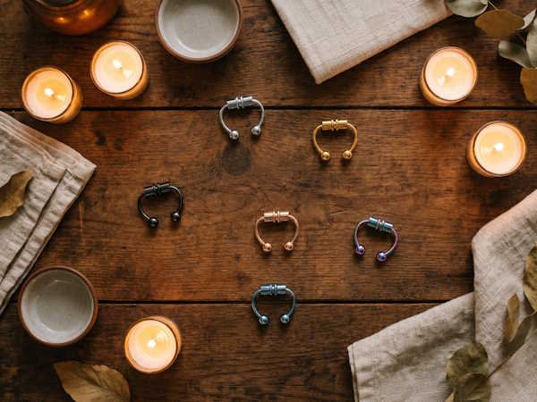Magnet Piercing – verschiedene magnetische Fake Piercing Studs auf dunklem Holz