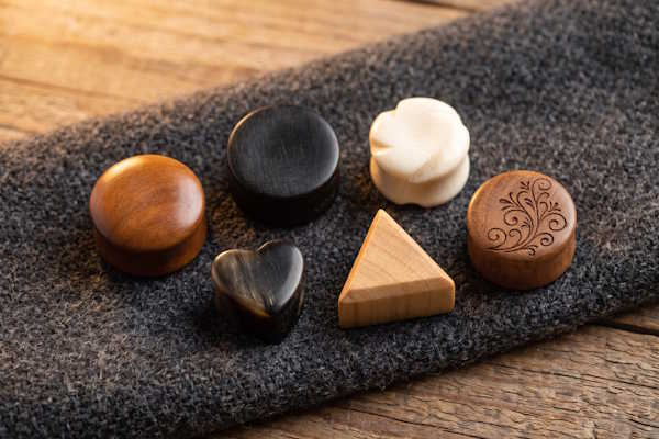 Auswahl geschlossener Ohr Plugs aus Holz, Horn und Knochen in runder, Herz- und Dreiecksform