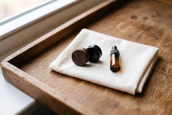 Holz und Horn Ohr Plugs mit weichem Tuch und kleiner Pflegeflasche auf Holztablett