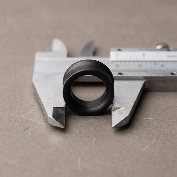 Schwarzer 10 mm Ohr Tunnel zwischen den Backen einer Metallschieblehre